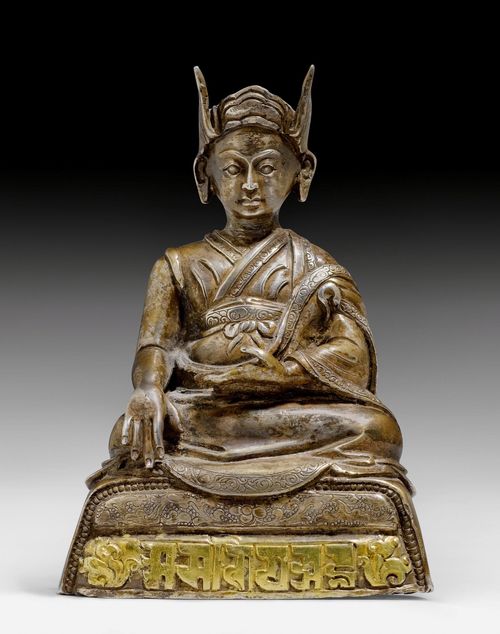 A SEATED SILVER MONK WITH THE GILT SIX SYLLABLE MANTRA IN LANTSA SCRIPT.