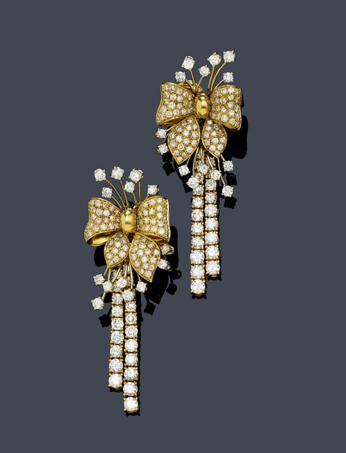 DIAMOND EAR PENDANTS. Yellow gold 750. Attractive ear clips with studs, each of 1 bow motif set with brilliant-cut diamonds. Suspended therefrom: 2 flexibly mounted lines of brilliant-cut diamonds. Total weight of the brilliant-cut diamonds ca. 6.50 ct. L ca. 6.5 cm.