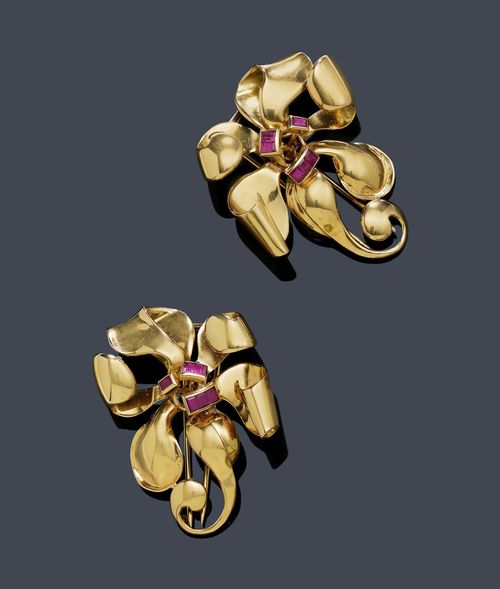 PAIR OF GOLD AND RUBY CLIP BROOCHES, ca. 1940. Pink gold 750, 30g. Decorative, sculptured brooches designed as stylised blossoms, each with the centre decorated with 6 baguette-cut rubies, weighing ca. 0.20 ct in total. Ca. 4.5 x 4 cm.