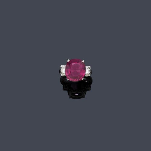 GARNET AND DIAMOND RING. White gold 750. Classic-elegant ring, the top set with 1 antique-oval, fine rhodolite of 10.63 ct, flanked by 2 baguette-cut diamonds and 16 small brilliant-cut diamonds weighing ca. 0.20 ct in total. Size ca. 54. With HKD Report (Diamond Laboratories Canada) No. 895131218GITH, December 2013.
