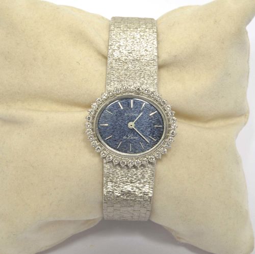 DIAMOND LADY'S WRISTWATCH, ETERNA, 1970s. White gold 750, 58g. Ref. 894 LEB 357. Oval case No. 6173161 with brilliant-cut diamond lunette weighing ca. 0.70 ct. Blue, engraved dial with white/silver-coloured indices and white hands. Hand winder, movement No. 6196671, Cal. 1438K. Textured brick-pattern gold band, signed. L ca. 18 cm. D 25 x 28 mm.
