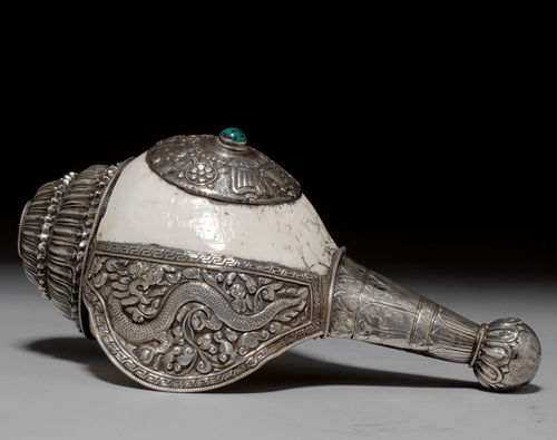 A CONCH SHELL HORN WITH SILVER MOUNTS CHASED AND ENGRAVED WITH THE ASHTMANGALA. Tibet, 20th c. Length 23.5 cm.