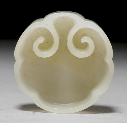A LIGHT GREEN JADE BRUSH HOLDER IN THE FORM OF A RUYI HEAD.