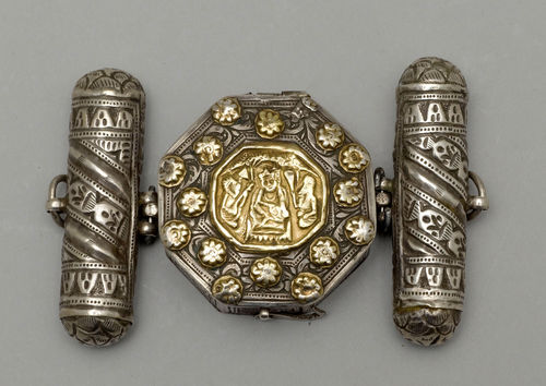A PARCEL-GILT SILVER OCTAGONAL UPPER-ARM AMULET CASE WITH LATERAL CAPSULES.