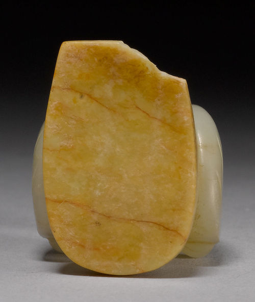 A SMALL PALE CELADON AND YELLOWISH JADE CARVING OF A KNEELING ...