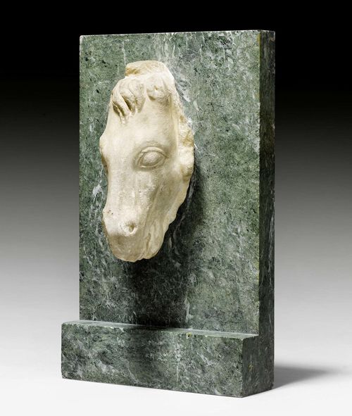 MARBLE HEAD OF A HORSE,Roman, 2nd century AD. White marble. Fragment. Mounted on "Vert de Mer" slab. Head H 17 cm. Slab 18.7x31.5 cm.