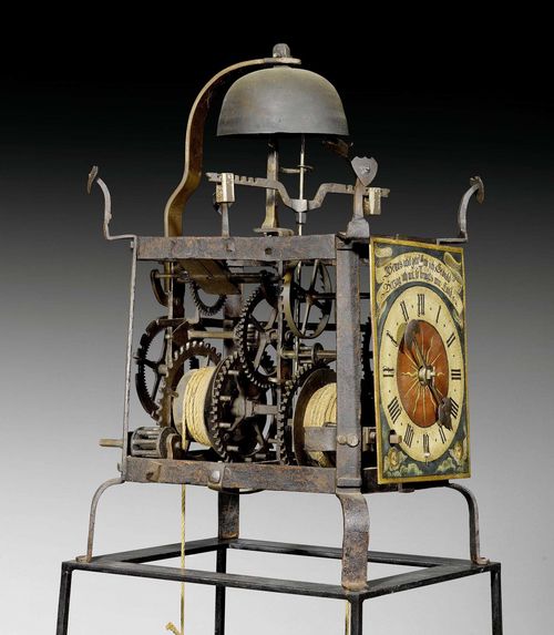 PAINTED TOWER CLOCK,Renaissance, Switzerland circa 1520/40. Chased iron. Open case with exceptionally fine corner pinnacles and prominent bell cage on a later framework. Finely painted, supplemented dial with the adage "WENNS UBEL GEHT HAB ICH GEDULD/VERZAG ICH NIT SO BRINGTS MIR HULD". Fine iron movement with striking and clockwork mechanism with foliot, hour striking on bell and hammer in the form of a mythical creature. 37x41x70 cm. H with stand 207 cm.