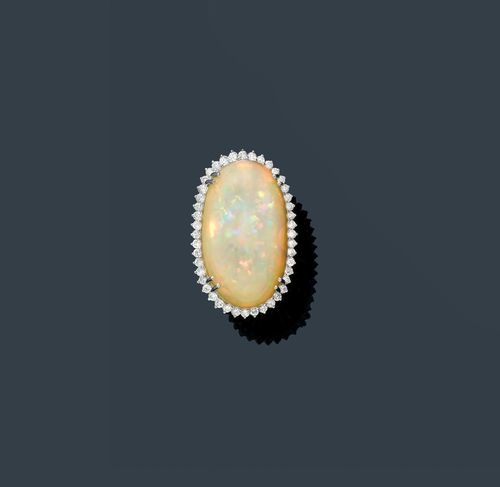 OPAL AND DIAMOND RING. White gold 750. Large, decorative ring. The top set with 1 oval cabochon weighing ca. 42.65 ct within a border of numerous brilliant-cut diamonds weighing ca. 1.60 ct in total. Size ca. 55.