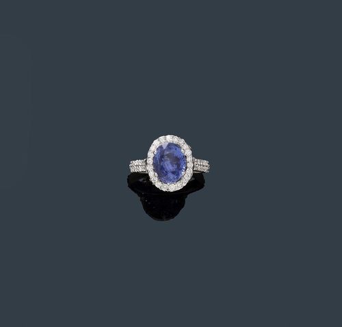 SAPPHIRE AND DIAMOND RING. White gold 750. Decorative, elegant ring. The top set with 1 oval Ceylon sapphire weighing 4.12 ct, unheated, within a border of numerous brilliant-cut diamonds. Setting and ring shoulders additionally decorated with brilliant-cut diamonds. Total weight of the diamonds ca. 1.10 ct. Size ca. 53. With SGL Report No. 02011861, December 2013.