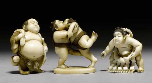THREE IVORY NETSUKE IN THE FORM OF SUMO WRESTLERS.