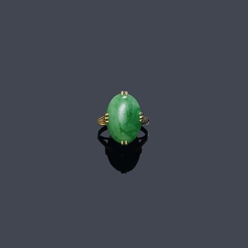 A JADEITE RING, circa 1920. Pink gold. Set with one jadeite cabochon of ca. 16 x 12 mm. Size ca. 49. Tested by Gemlab.