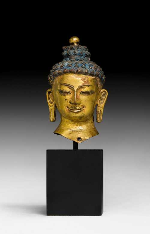 A GILT COPPER HEAD OF BUDDHA.