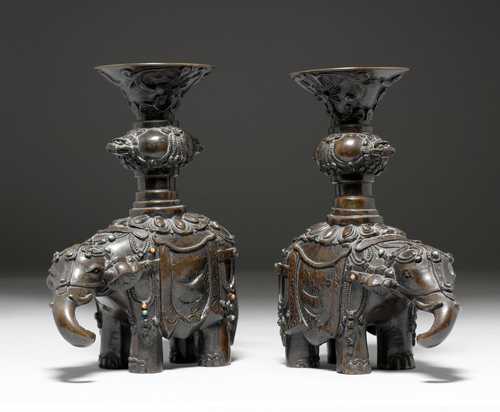 TWO BRONZE CANDLESTICKS IN THE SHAPE OF ELEPHANTS.