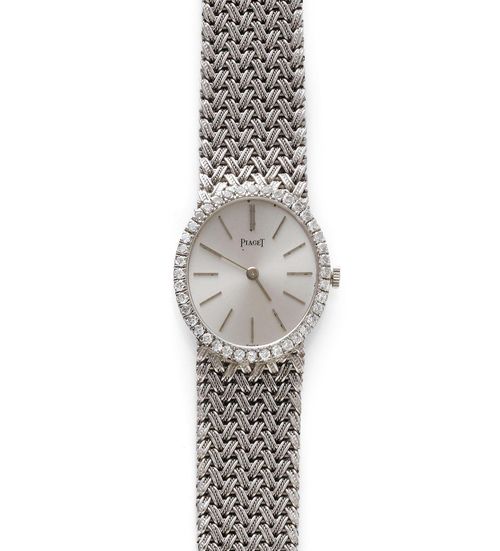 DIAMOND LADY'S WRISTWATCH, PIAGET, 1970s. White gold 750, 48g. Ref. 9826 D1. Oval, extra-flat case No. 139035 with brilliant-cut diamond lunette weighing ca. 0.60 ct. Silver-coloured, satin-finished dial and silver-coloured indices and baton hands. Hand winder, extra-flat movement No. 685346, Cal. 9P, with gold pallet and gold escapement wheel. Braided gold band, signed, L 16.5 cm. D 27 x 24 mm.