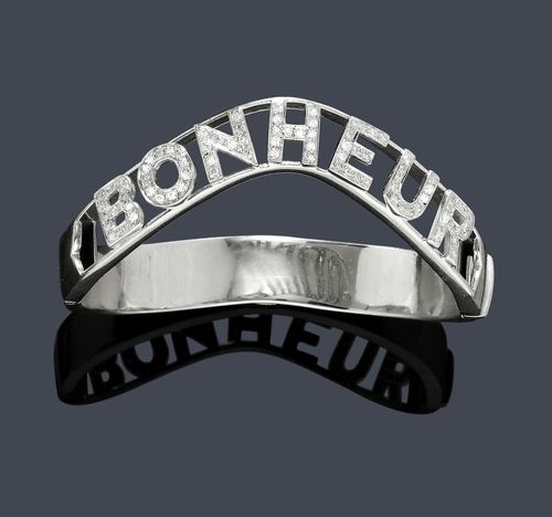 GOLD AND DIAMOND BANGLE. Yellow gold 750, rhodium-plated, 50g. Decorative bangle with hinge, the wavy outside with the inscription "BONHEUR" of diamond-set letters held by 2 gold bands. Total weight of the single-cut diamonds ca. 0.70 ct. Ca. 6 x 5.5 cm.