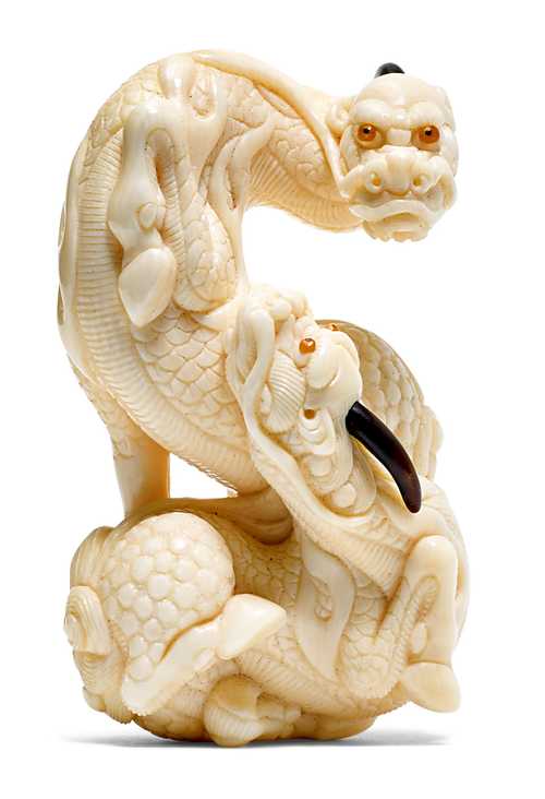A MAMMOTH TOOTH NETSUKE CARVED AS TWO INTERTWINED KIRIN BY SAITO BISHU (*1943).