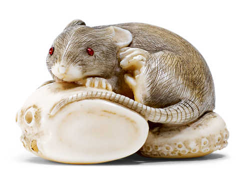 AN IVORY NETSUKE OF A RAT ON A OCTOPUS TENTACLE.