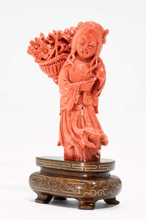 A CARVED CORAL FIGURE OF A GIRL WITH A FLOWER BASKET.