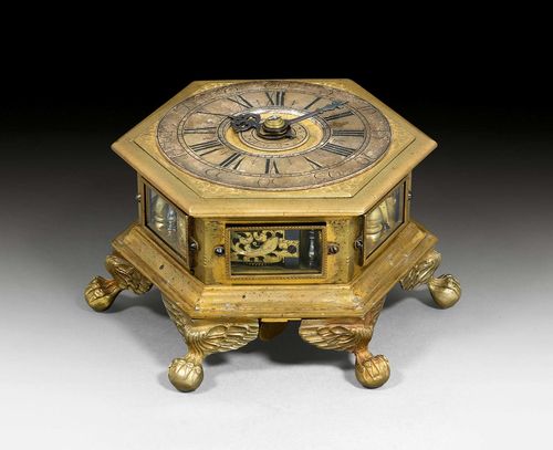 TABLE CLOCK,Baroque, the movement signed BENJAMIN ZOLL DANZIG (Benjamin Zoll, active 1681-1761), circa 1730. Bronze and brass, partly with fine volute engraving. Glazed sides. Silver chapter ring with Roman hours and Arabic minutes, as well as smaller dial with Arabic numerals 1-12. Exceptionally fine movement with striking on 2 bells. Requires servicing. 17x17x9.5 cm.