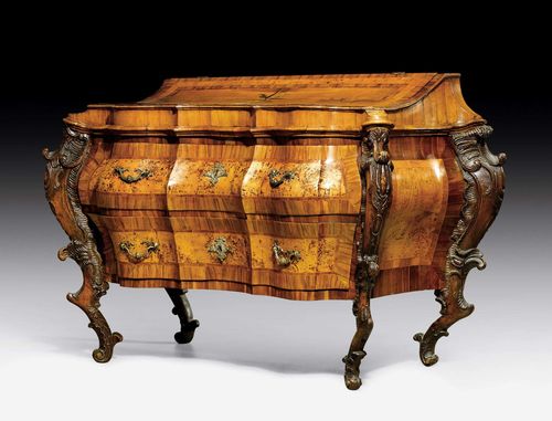 COMMODE WITH UPPER SECTION,Baroque, probably Mainfranken circa 1740. Exceptionally richly carved walnut, plumwood and birch burlwood inlaid with reserves and decorative frieze. The front with 2 drawers. Later upper section with sloped, concave and hinged top, the interior with 2 adjacent drawers. Bronze mounts and drop handles. 140x80x120 cm. Provenance: - Former German aristocratic collection, Mainz. - Swiss private collection.