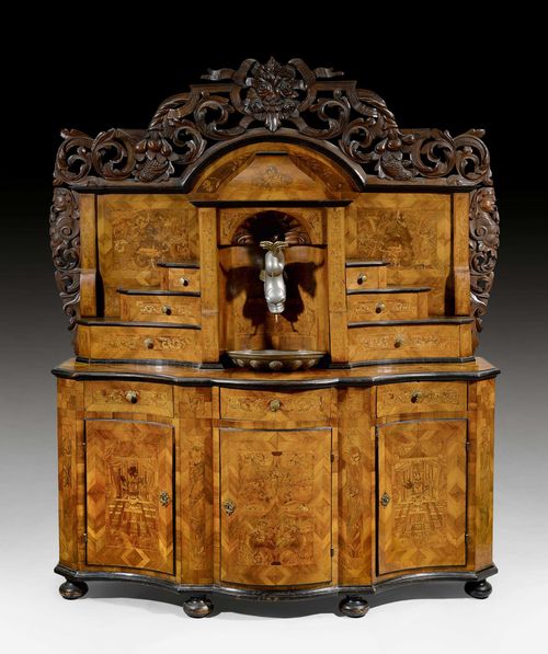 BUFFET WITH UPPER SECTION,Baroque, Beromunster circa 1730/35. Walnut, burlwood and local fruitwoods in veneer, partly ebonised and with fine inlays. The lower section with central drawer below drawer, between 2 analogously arranged doors below drawers. Recessed upper section with central niche with pewter watering receptacle and basin, flanked on each side by 3 various-sized drawers. Bronze mounts and applications. 196x65x220 cm.