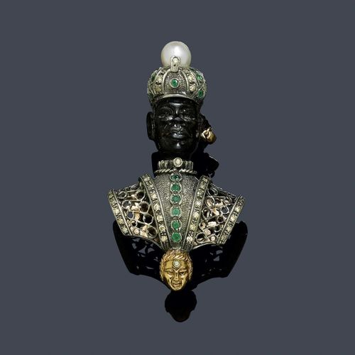 PEARL, GEMSTONE AND DIAMOND CLIP BROOCH, ca. 1945. Silver and pink gold 375. Decorative "Moretto" with a finely carved head of wood. The turban is decorated with 1 cultured pearl of ca. 7.5 mm Ø, 21 small emeralds and 13 diamonds. Finely engraved, open-worked garment with 6 emeralds and numerous small diamonds. 1 ruby pendant as an earring and 1 mask motif with a diamond. Ca. 6.2 x 3.5 cm.