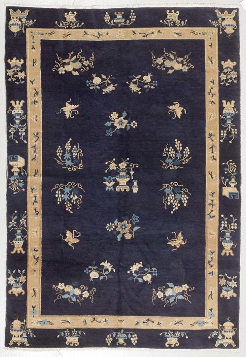 CHINA old.Dark blue central field, patterned throughout with floral motifs, blue and beige edging with a similar pattern, slight wear, 158x230 cm.
