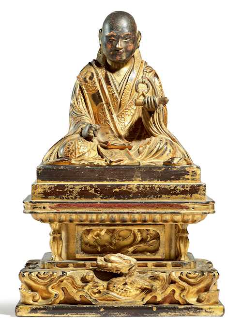 A GILT LACQUERED WOOD FIGURE OF A SEATED NICHIREN MONK.
