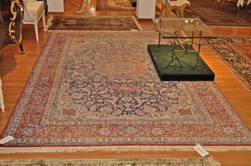 ISFAHAN.Blue central field with central medallion and white corner motifs, patterned with flower tendrils and palmettes, red border, slight traces of wear, 200x300 cm.