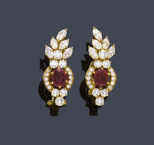RUBY AND DIAMOND EAR CLIPS. Yellow gold 750. Decorative ear clips with studs with a stylized flower and leaf motif, each set with 1 fine, oval ruby, total weight of the rubies ca. 2.20 ct, each ruby within a border of 5 navette-cut diamonds weighing ca. 1.00 ct and 16 brilliant-cut diamonds. Total weight of the diamonds ca. 1.50 ct.