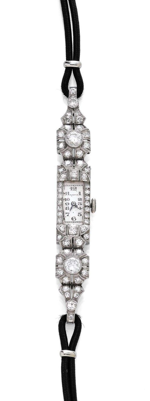 DIAMOND LADY'S WRISTWATCH, MARVIN, ca. 1925. Platinum. Rectangular, laterally engraved case with diamond lunette and diamond-set attaches weighing ca. 1.30 ct. Silver-coloured dial with Arabic numerals and blued hands, signed Marvin. Hand winder, form movement, signed Swiss Made. Original corded band with metal clasp, L ca. 17 cm.