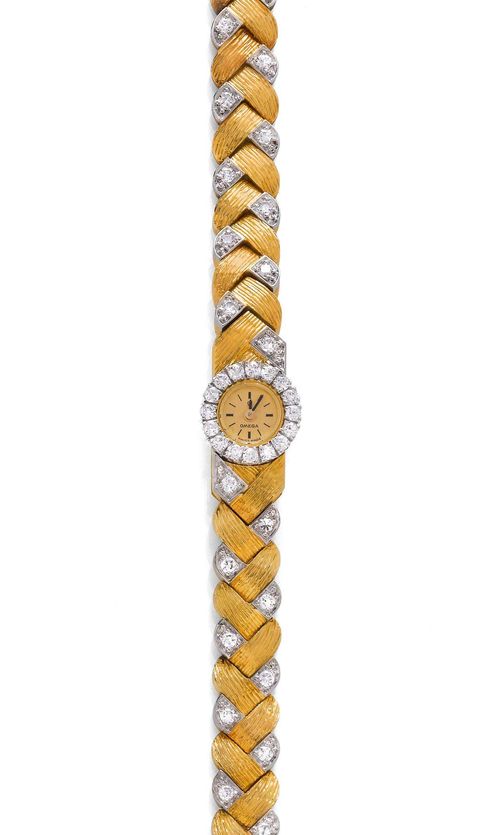 DIAMOND LADY'S WRISTWATCH, OMEGA, ca. 1950. Yellow and white gold 750, 44g. Rectangular case No. 566315 integrated in the band, with a round, brilliant-cut diamond-set lunette and crown on the back. Gold-coloured mini dial with black indices and hands. Hand winder, form movement No. 18647665, Cal. 690. Decorative, bicolour band with textured braid pattern set with 34 brilliant-cut diamonds weighing ca. 0.60 ct. Does not run: resinified. L ca. 19 cm. D 9 x 12 mm.