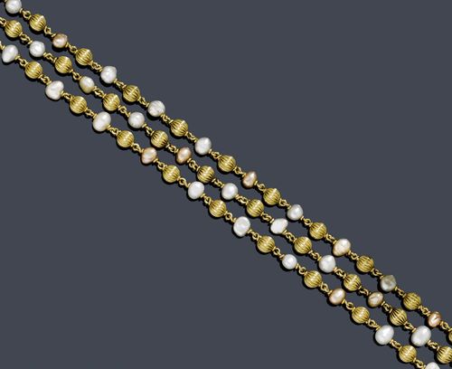 GOLD AND PEARL SAUTOIR, ca. 1950. Yellow gold 750, 170g. Long, decorative necklace of numerous small, ribbed gold beads of ca. 4.8 mm Ø, alternately strung with numerous, baroque Biwa cultured pearls. L ca. 51 cm.