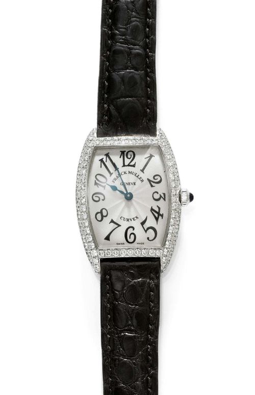 DIAMOND LADY'S WRISTWATCH, FRANK MULLER. White gold 750. Ref. 1752 QZ D, Curvex model. Tonneau-shaped case No. 276 with screw-down back and sapphire-set crown. Silver-coloured, engine-turned dial with black Arabic numerals and black hands, signed. Quartz movement. Black leather band with diamond-set clasp. D 35 x 25 mm. With case, Certificat d'Origine and warranty. January 2000.
