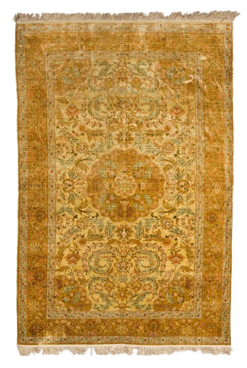 HEREKE SILK.With a floral central medallion and corners on a beige central field, finely patterned in trailing flowers in delicate pastel colours, and with a light blue border with floral motifs. Slightly worn, 150x245 cm.