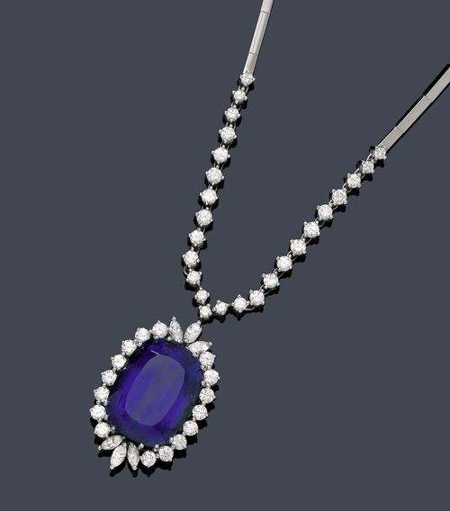 TANZANITE AND DIAMOND NECKLACE, BUCHERER. White gold 750. Classic-elegant bar necklace, the front decorated with 25 brilliant-cut diamonds and 1 flexibly mounted pendant, set with 1 very fine, antique-oval tanzanite of 22.09 ct, within a border of 6 navette-cut diamonds weighing 0.60 ct and 16 brilliant-cut diamonds. Total weight of the brilliant-cut diamonds 3.28 ct. L ca. 40.5 cm. With case and certificate by Bucherer, July 1979.