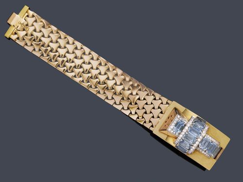 AQUAMARINE, DIAMOND AND GOLD BRACELET, CARTIER, ca. 1945. Pink and yellow gold 585. Decorative bracelet with a fantasy braid pattern, the front decorated with 1 rectangular, asymmetric buckle motif decorated with 10 step-cut aquamarines weighing ca. 12.00 ct as well as numerous brilliant-cut diamonds and single-cut diamonds weighing ca. 2.30 ct in total. Signed Cartier, V.C. Perren. W ca. 2.6 cm, L ca. 19 cm.