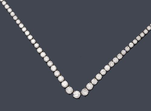 DIAMOND NECKLACE, ca. 1950. Platinum 950. Elegant, classic Rivière necklace set with 85 graduated,  brilliant-cut diamonds of  6.4 to 2.9 mm Ø. Clasp additionally decorated with 15 brilliant-cut diamonds. Total weight of the brilliant-cut diamonds ca. 28.40 ct. L ca. 41 cm.