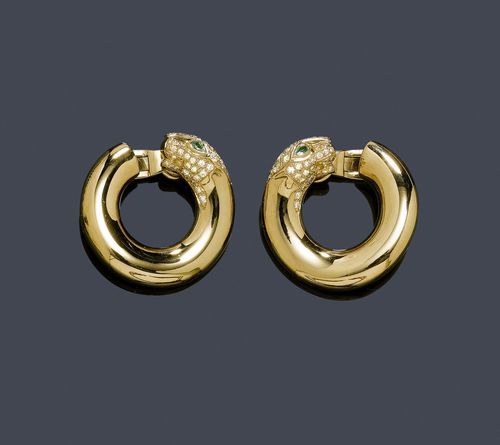 DIAMOND, EMERALD AND GOLD EAR CLIPS, CARTIER. Yellow gold 750, 23g. Panthère model, 1925, Ref. B8014200. Polished creole ear clips, the lower part designed as a panther head, set with brilliant-cut diamonds, 66 brilliant-cut diamonds in total weighing ca. 0.93 ct, and 2 small drop-cut emeralds weighing ca. 0.08 ct. as eyes. With copy of invoice.