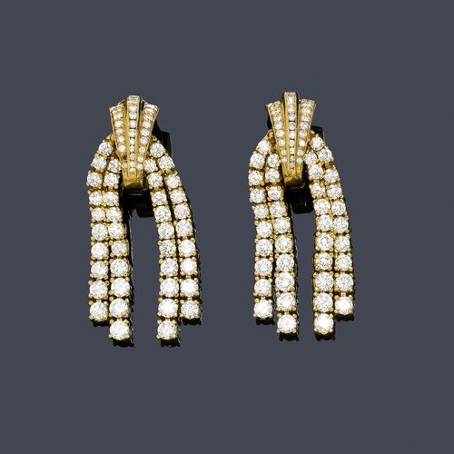 DIAMOND EAR CLIPS, MERSMANN. Yellow gold 750. Decorative half-creole ear clips, set throughout with 30 brilliant-cut diamonds weighing ca. 1.00 ct, 1 small diamond missing, and 2 double diamond lines with a total of 80 graduated brilliant-cut diamonds weighing ca. 6.00 ct. L ca. 4 cm. With copy of insurance estimate, July 1992.