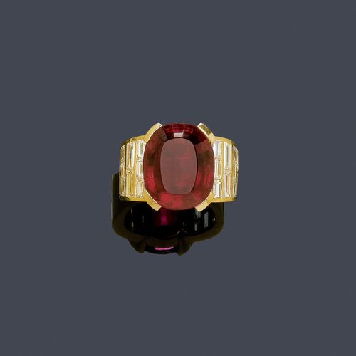 TOURMALINE AND DIAMOND RING, BINDER. Yellow gold 750. Fancy band ring, the top set with 1 fine, oval rubellite of ca. 13.34 ct, the broad ring shoulders set throughout with 20 tapered baguette-cut diamonds weighing ca. 3.51 ct. Size ca. 57. With copy of insurance estimate, February 2002.