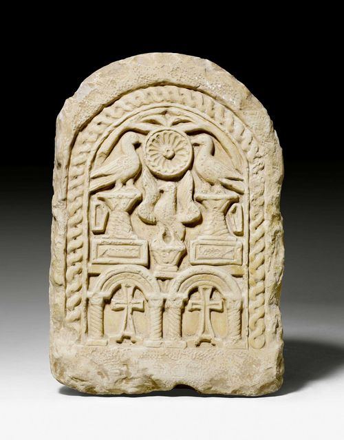 STELE, Coptic, 6th/7th century A.D. Light beige stone in relief. Rounded, profiled plate with a central rosette flanked by birds, the lower part with 2 adjacent crosses. H 45 cm. Provenance: Swiss private collection.
