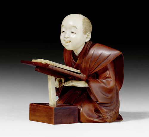 AN IVORY AND WOOD OKIMONO OF A KNEELING MAN WITH BOOK. Japan, Meiji period, height 9 cm. Signed.