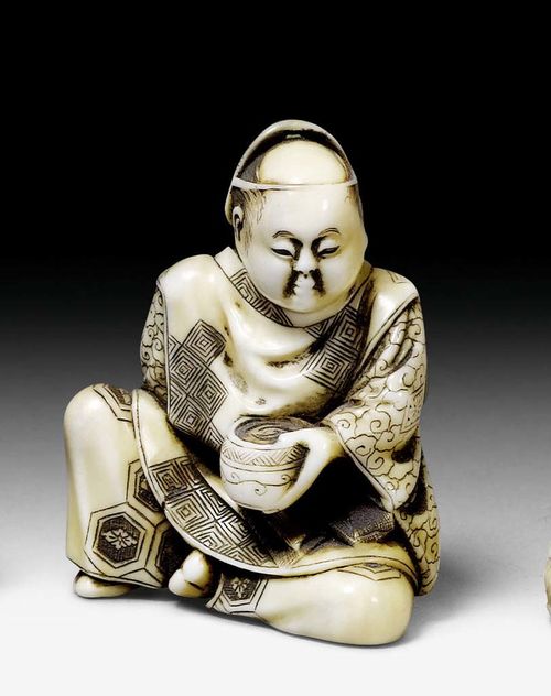AN IVORY NETSUKE OF AN ACTOR WITH A MASK ON THE BACKSIDE OF HIS HEAD. Japan, Meiji period, height 3.7 cm.