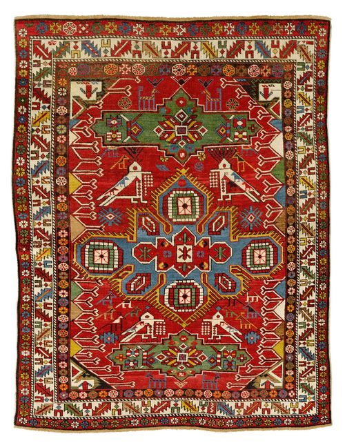 FACHRALO antique.Red ground with blue, green medallions, geometrically patterned with stylised plants and birds, white border, slight signs of wear, 120x162cm.