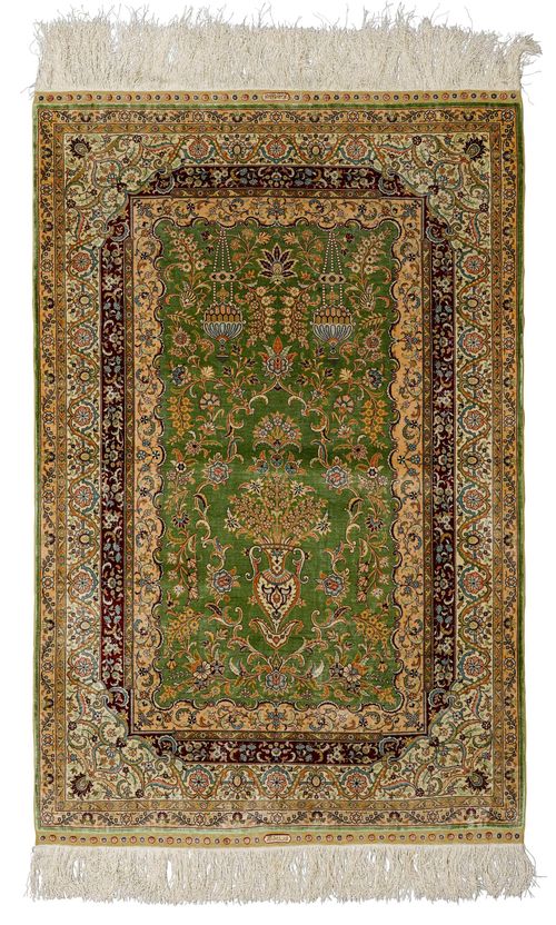 HEREKE SILK.Fineness: 10x10 knots/cm2. Green central field finely patterned with a flower vase, lantern motifs and trailing flowers, white border, in good condition, 110x160cm.