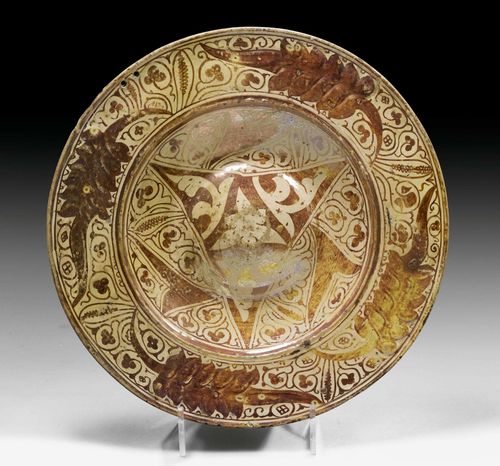 HISPANO-MORESQUE PLATE WITH LUSTER GLAZE, SPAIN, PROBABLY CATALONIA, CIRCA 1580. With hump in the center and broad flat rim. D 35.5 cm. Light restoration and luster rubbed.