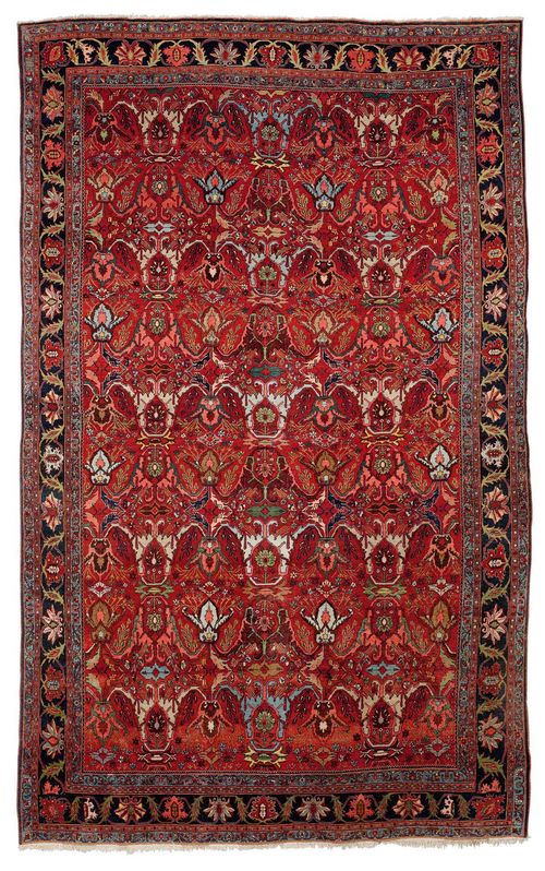 FERAGHAN old.Red ground, patterned throughout with stylised plant motifs in bright colours, black border with trailing flowers, signs of wear in some areas, 252x380 cm.