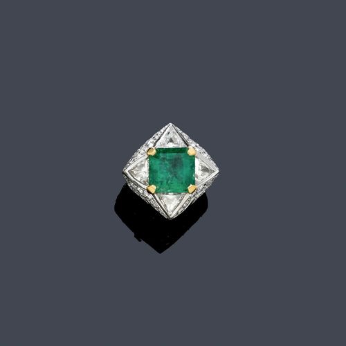 EMERALD AND DIAMOND RING. White and yellow gold 750. Elegant, modern ring, the top set with 1 step-cut Columbian emerald weighing ca. 6.00 ct, with signs of wear, within a border of 2 trilliant-cut diamonds and 2 triangle-cut diamonds. Total diamond weight ca. 2.80 ct. Set throughout with 48 brilliant-cut diamonds weighing ca. 2.00 ct in total. Size ca. 52, with size adjustment insert. Oral estimate by GGTL/Gemlab.