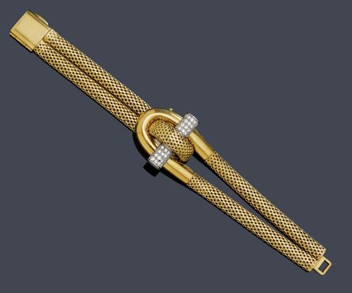 DIAMOND LADY'S WRISTWATCH, GAUCHERAND, Paris, ca. 1945. Yellow and white gold 750, 79g. Decorative bracelet of double tubular chain, the centre designed as a toggle closure, decorated with 1 cylindrical, toggle knob in white gold set with brilliant-cut diamonds weighing ca. 0.70 ct as the sprung cover of the watch. Small asymmetrical case, signed Gaucherand Paris with rectangular, silver-colored dial, gold-colored indices and hands. Hand winder, octagonal movement, unsigned. L ca. 17.5 cm.